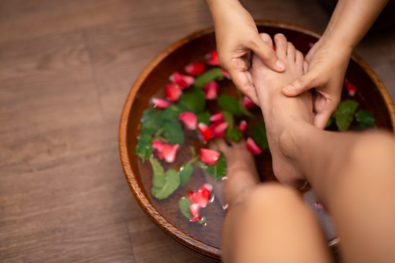 Top View  shot of a woman feet dipped in water with petals in a